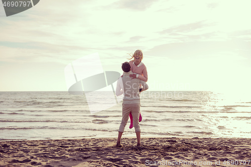 Image of Loving young couple on a beach at autumn sunny day