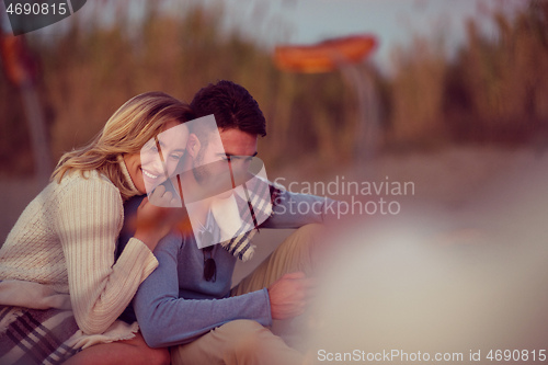 Image of Group Of Young Friends Sitting By The Fire at beach