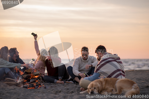 Image of Friends having fun at beach on autumn day