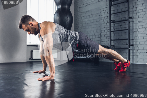 Image of The athlete trains hard in the gym. Fitness and healthy life concept.