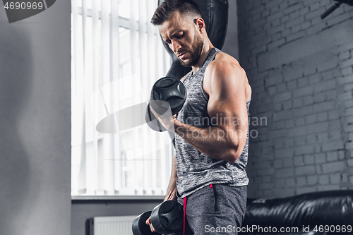 Image of The athlete trains hard in the gym. Fitness and healthy life concept.