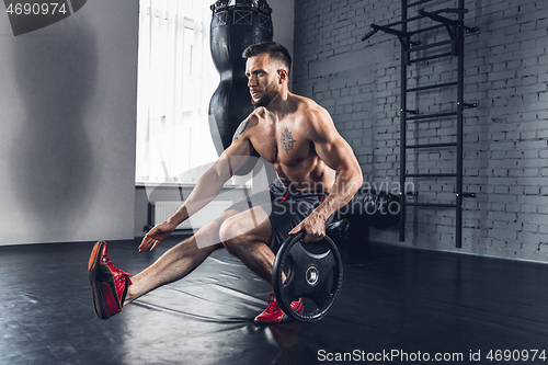 Image of The athlete trains hard in the gym. Fitness and healthy life concept.