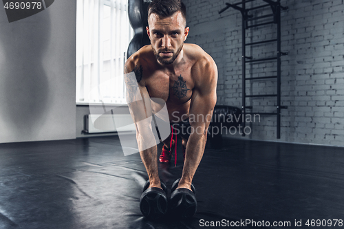 Image of The athlete trains hard in the gym. Fitness and healthy life concept.