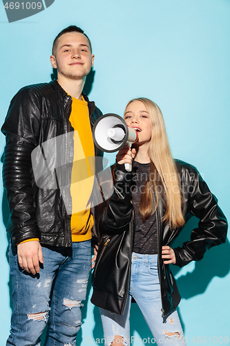 Image of Portrait of young emotional female student with megaphone