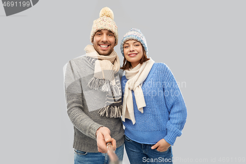 Image of happy couple in winter clothes taking selfie