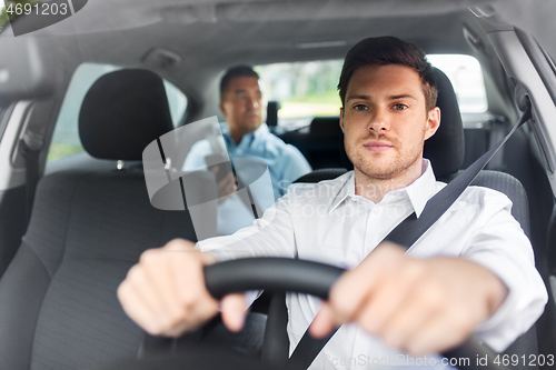 Image of male driver driving car with passenger