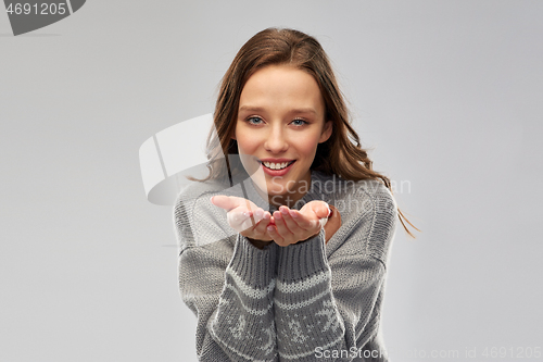 Image of woman in ugly christmas sweater holding something