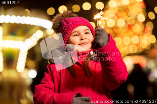 Image of happy girl with sparkler at christmas market