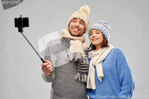 Image of happy couple in winter clothes taking selfie