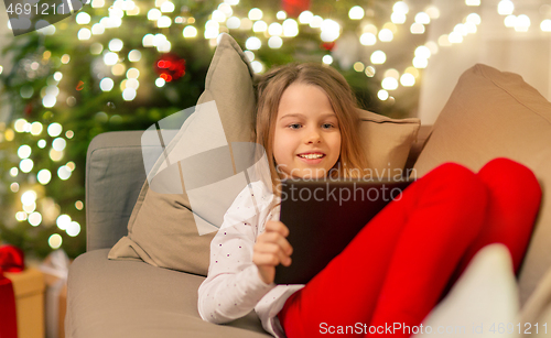 Image of smiling girl with tablet pc at christmas home