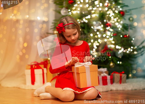 Image of girl with christmas gift at home
