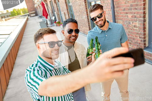 Image of men drinking beer and taking selfie by smartphone