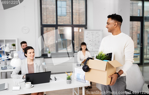 Image of happy male office worker with personal stuff