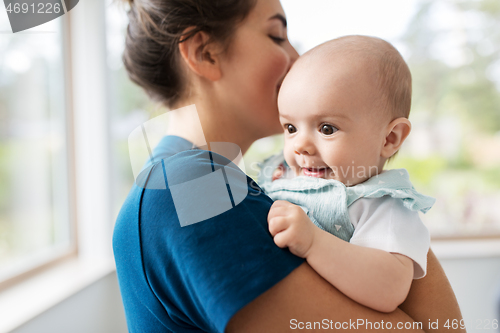 Image of mother holding baby daughter at home