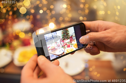 Image of hands photographing food at christmas dinner