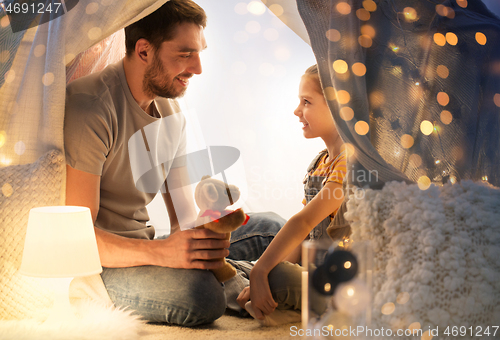 Image of happy family playing with toy in kids tent at home