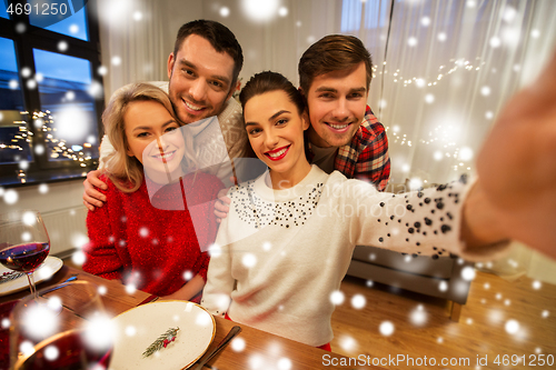 Image of friends taking selfie at christmas dinner