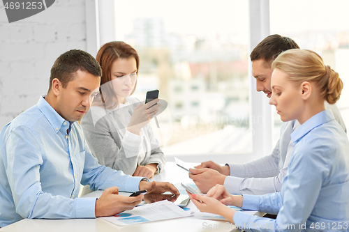 Image of business team using smartphones at office