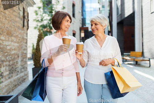 Image of senior women with shopping bags and coffee in city