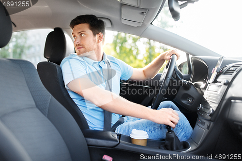 Image of man or driver driving car and looking back