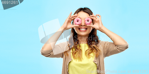 Image of happy asian woman with eyes of donuts