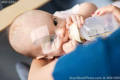 Image of close up of mother feeding baby with milk formula