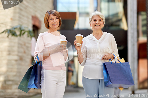 Image of senior women with shopping bags and coffee in city