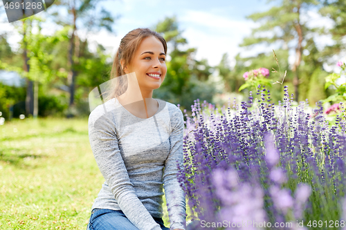 Image of young woman and lavender flowers at summer garden