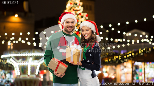 Image of happy couple with gifts at christmas market