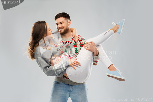 Image of happy couple at christmas ugly sweater party