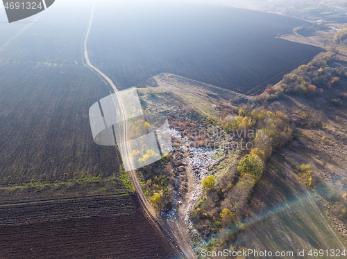 Image of Aerial view from a drone above landfill site and plowed agricultural fields.