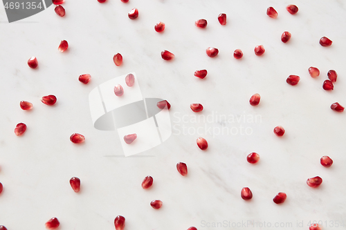 Image of Horizontal pattern from fresh juicy natural pomegranate seeds on a marble background.