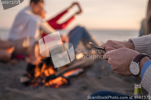 Image of Friends having fun at beach on autumn day