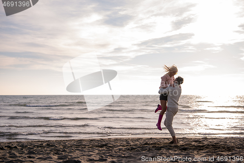 Image of Loving young couple on a beach at autumn sunny day