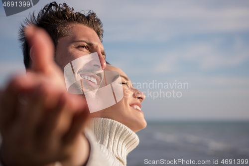 Image of Loving young couple on a beach at autumn sunny day