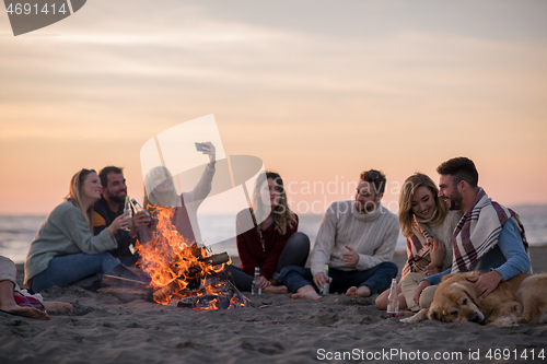 Image of Friends having fun at beach on autumn day