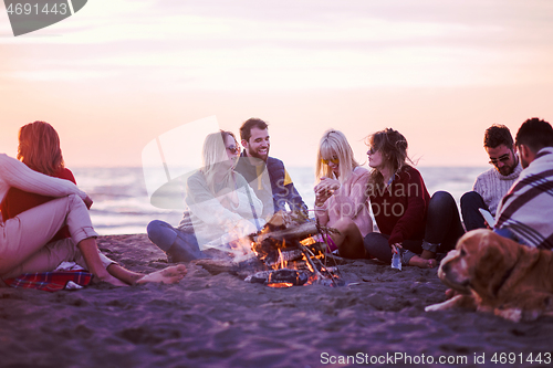 Image of Friends having fun at beach on autumn day