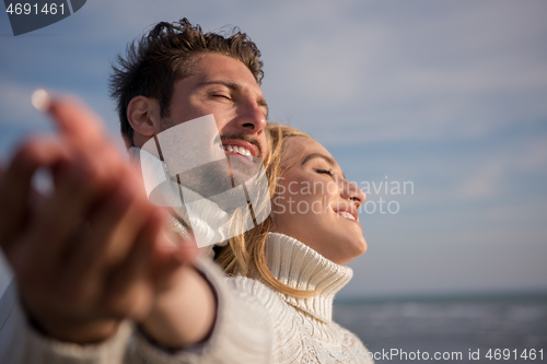 Image of Loving young couple on a beach at autumn sunny day