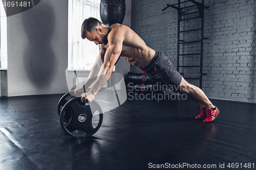 Image of The athlete trains hard in the gym. Fitness and healthy life concept.