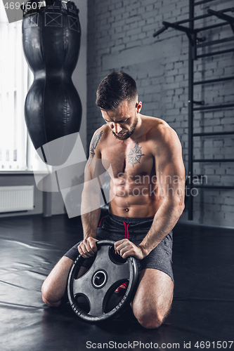 Image of The athlete trains hard in the gym. Fitness and healthy life concept.