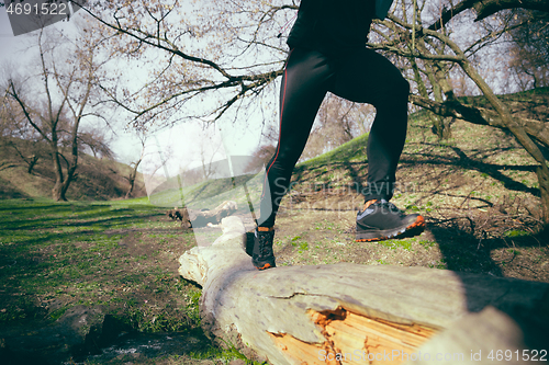 Image of Man running in a park or forest against trees background.