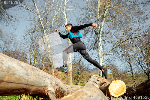 Image of Man running in a park or forest against trees background.