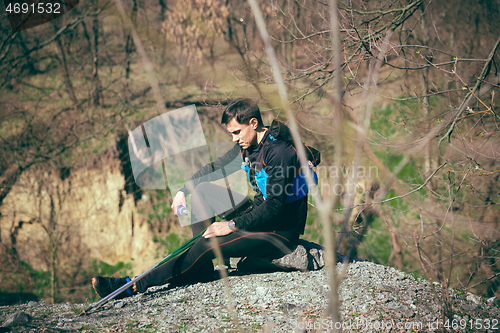 Image of Man after running in a park or forest against trees background.