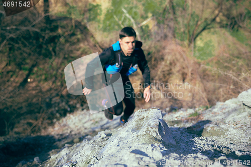 Image of Man running in a park or forest against trees background.