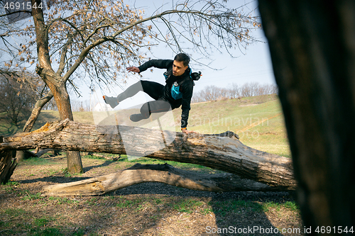 Image of Man running in a park or forest against trees background.