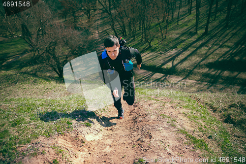 Image of Man running in a park or forest against trees background.