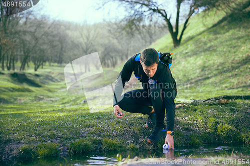 Image of Man after running in a park or forest against trees background.