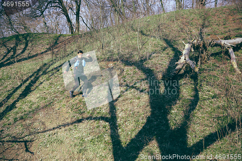 Image of Man running in a park or forest against trees background.