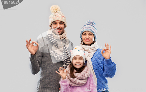 Image of happy family in winter clothes showing ok gesture