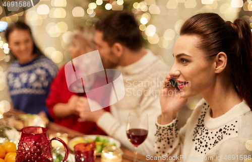 Image of woman calling on smartphone at christmas dinner